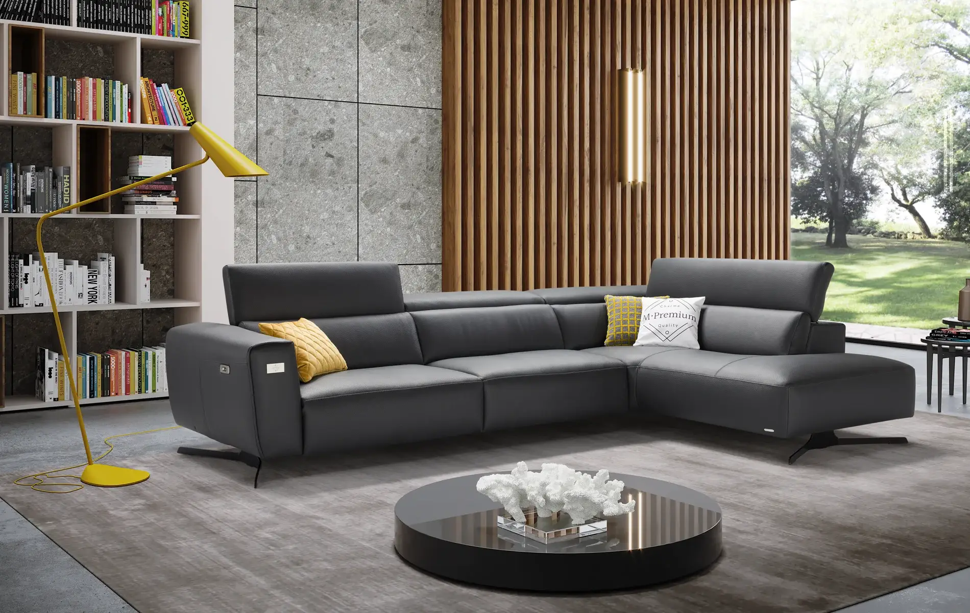 Divano Dogma Emerald Edition angolare in pelle nera in un living con libreria