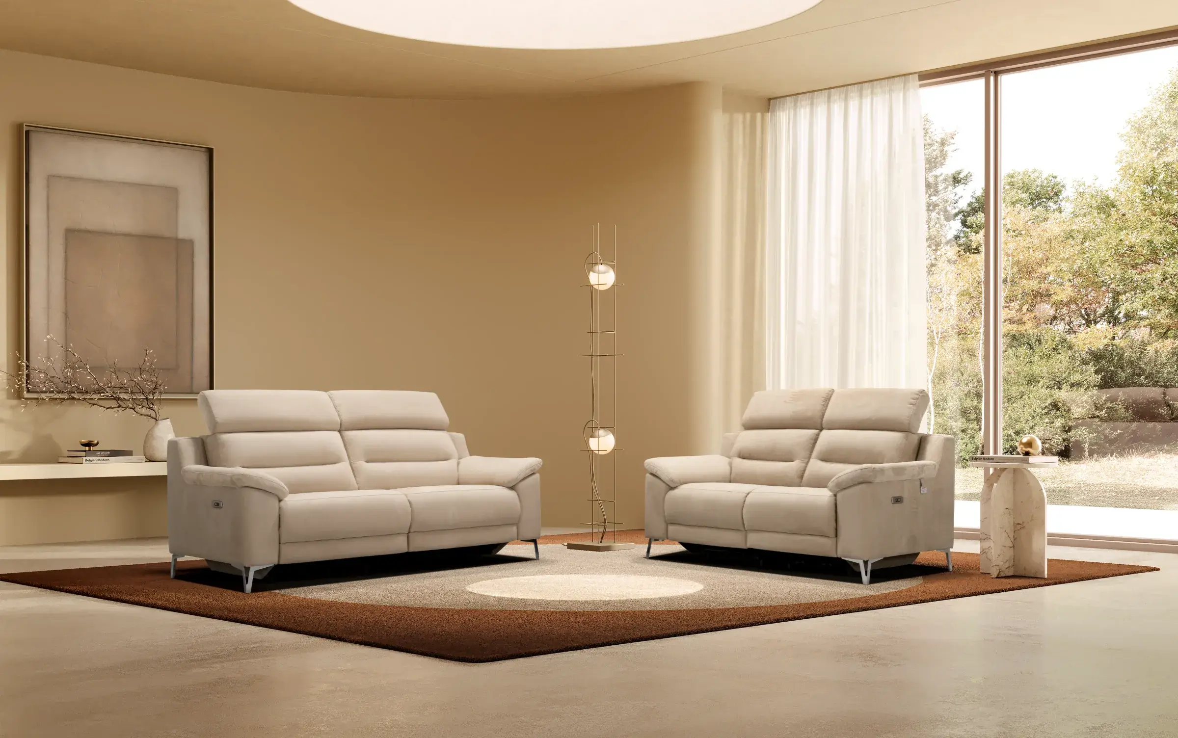 Divani Egeo tre posti e due posti beige in un living luminoso con tappeto marrone