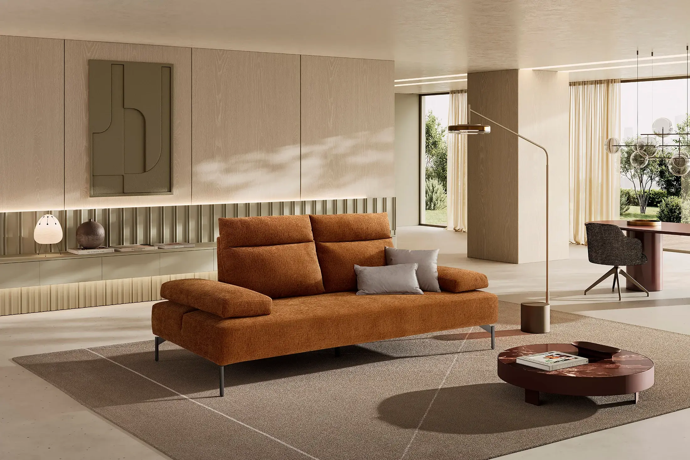 Divano Lionel in tessuto arancio bruciato in un living con tavolino rotondo e lampada ad arco