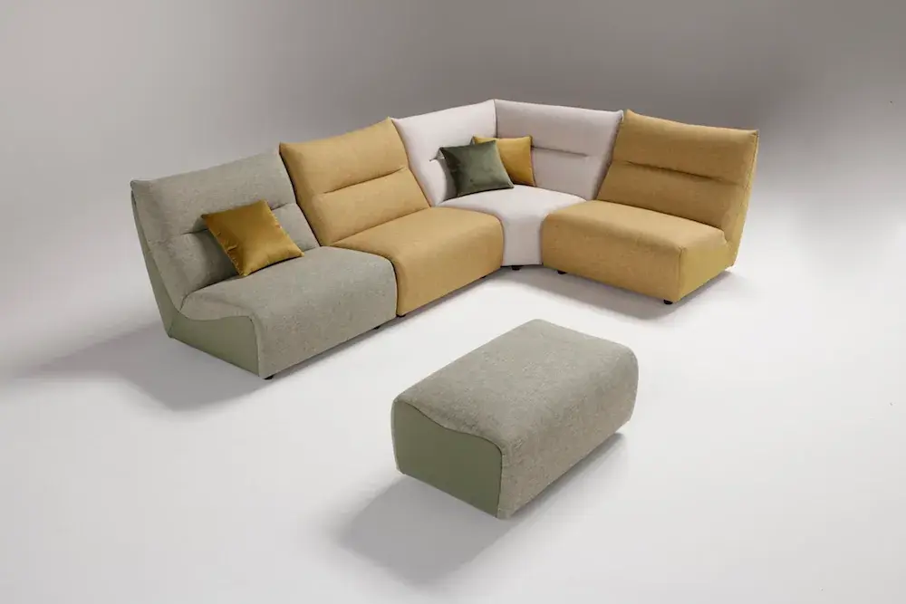 Composizione angolare di Melpot con moduli verde, ocra e crema e pouf separato, in studio