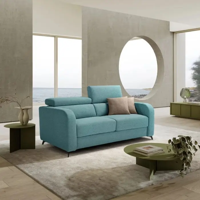 Divano letto Orion verde acqua in un living con finestra tonda