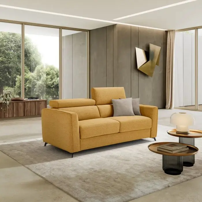 Divano letto Pegasus giallo senape in un living con tavolini bassi