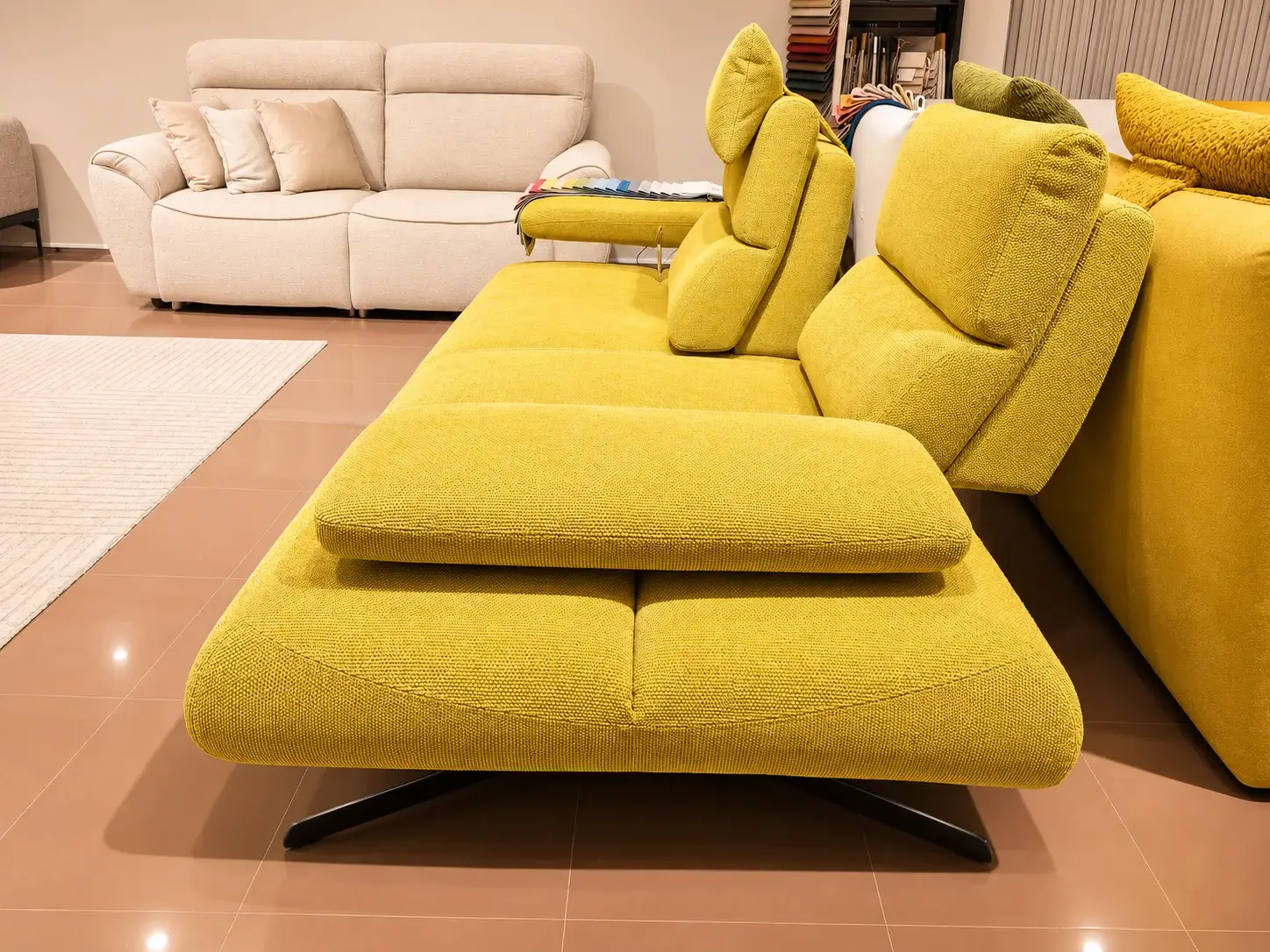 Divano con chaise longue in tessuto giallo chartreuse in primo piano nello showroom