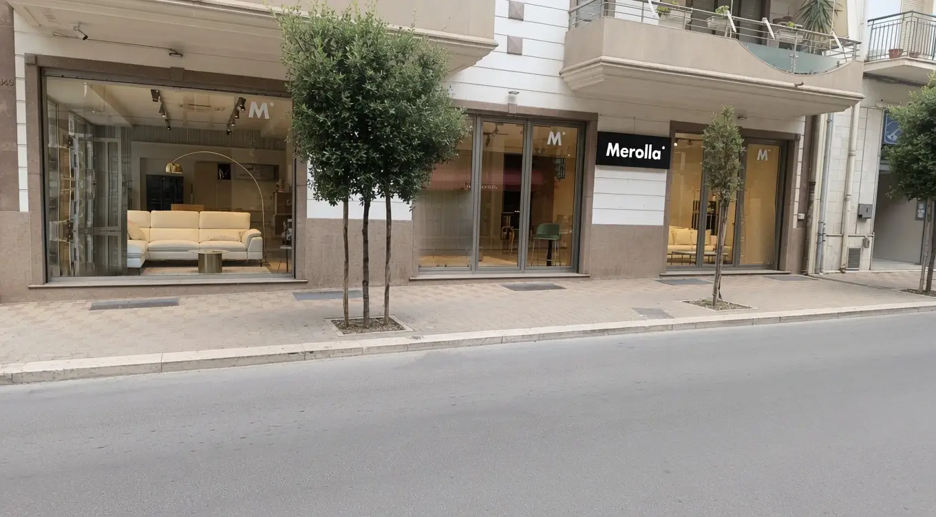 La vetrina dello showroom Merolla in Via Ragni a Gravina in Puglia, vista dalla strada, con l’insegna Merolla e i divani esposti