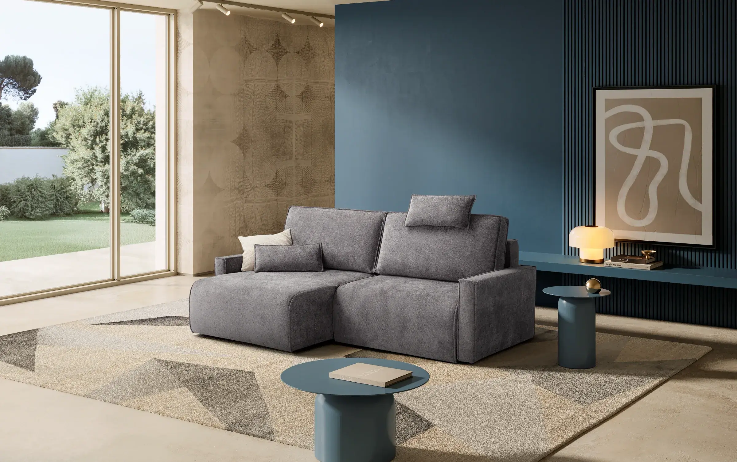Divano Sirio grigio con penisola in un living con parete blu e grandi vetrate